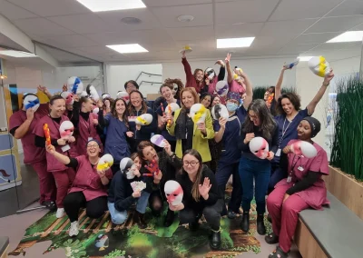 Équipe soignante en blouses posant avec des masques colorés après une session d'escape game à domicile en milieu hospitalier