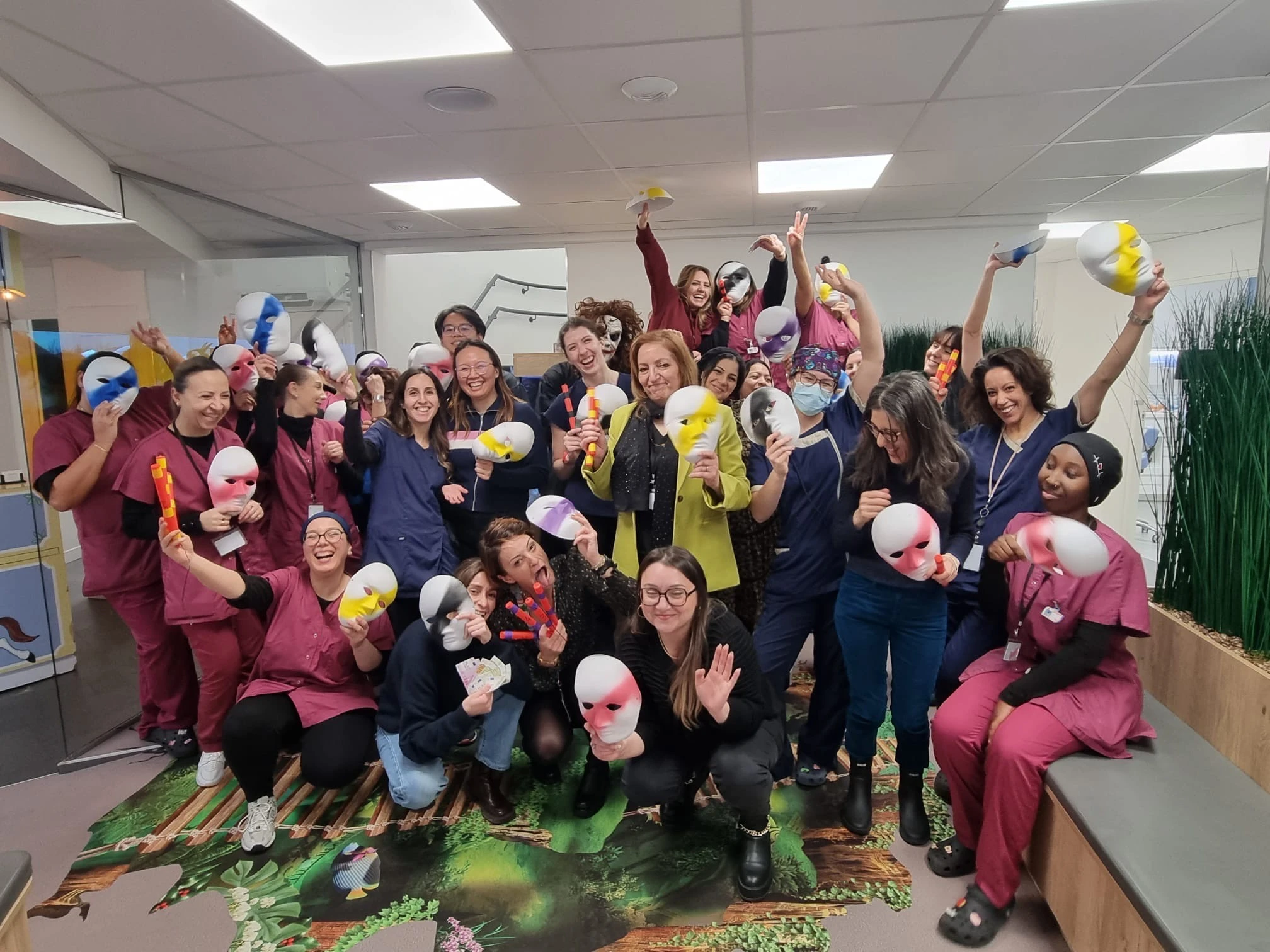 Équipe soignante en blouses posant avec des masques colorés après une session d'escape game à domicile en milieu hospitalier