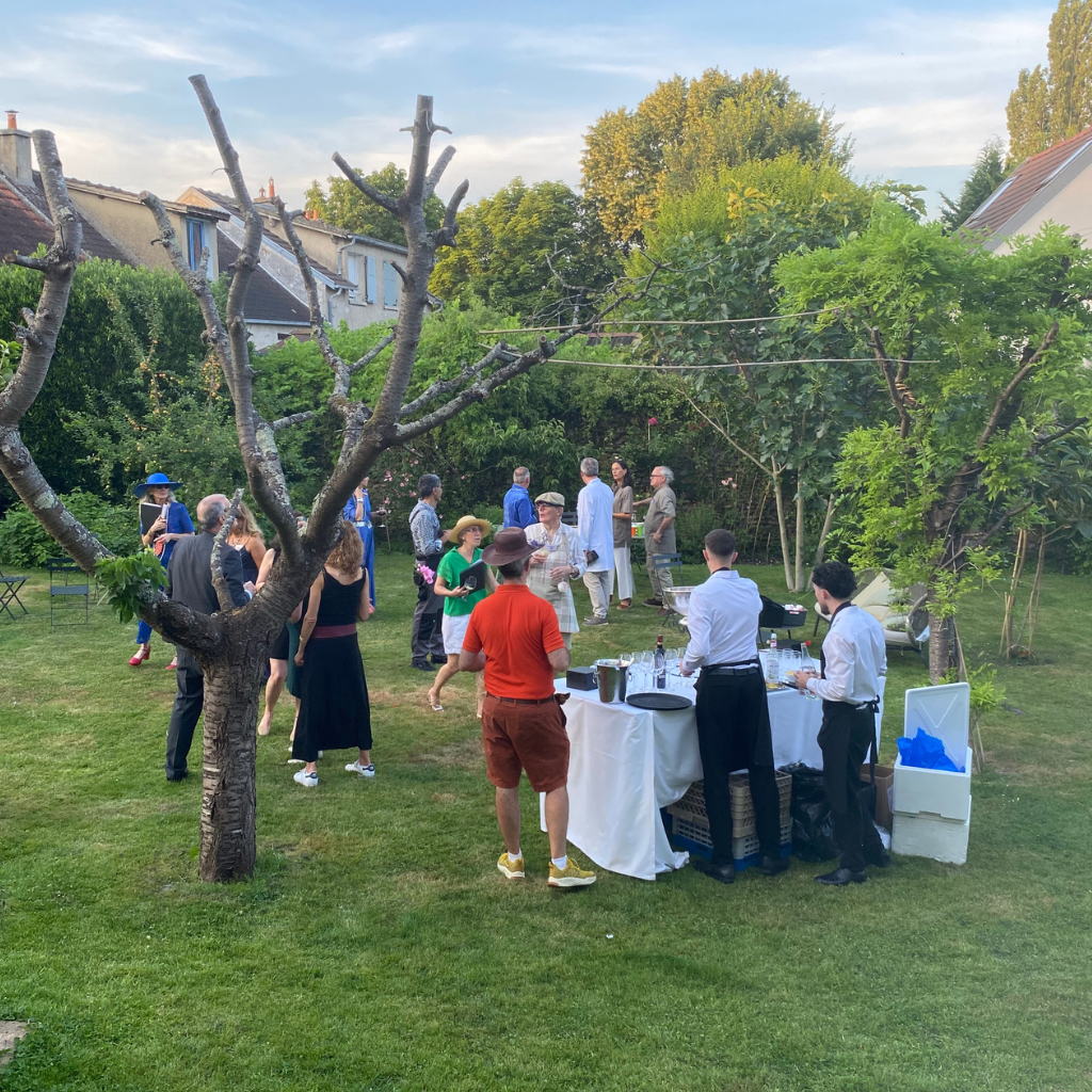 Invités réunis dans le jardin pendant le vin d'honneur d'un mariage